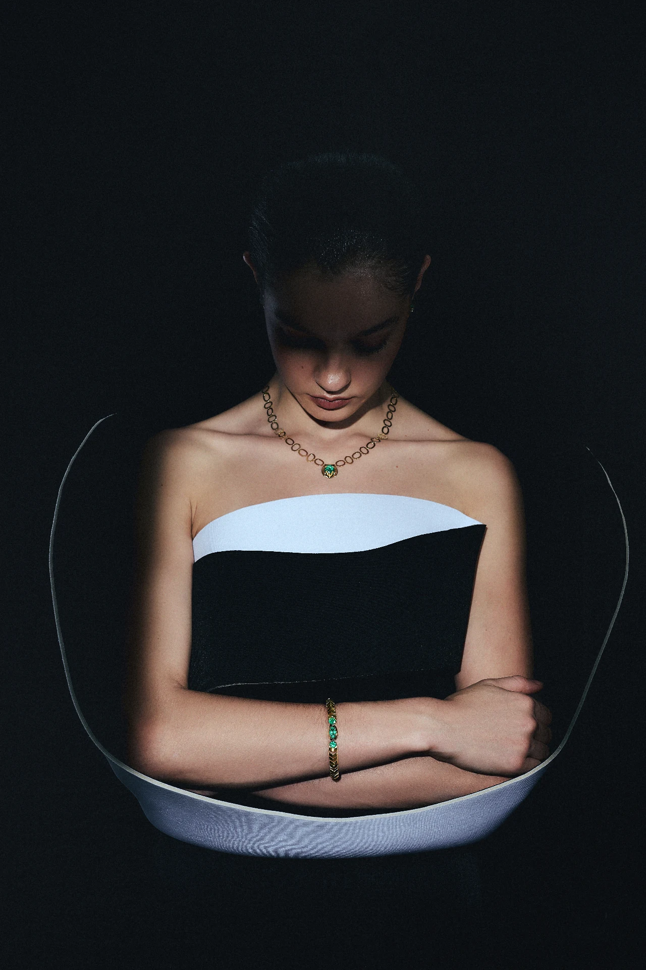 Editorial ORIGEM — colar de elos em ouro 18k com esmeralda Belmont e bracelete combinando, sobre vestido bicolor