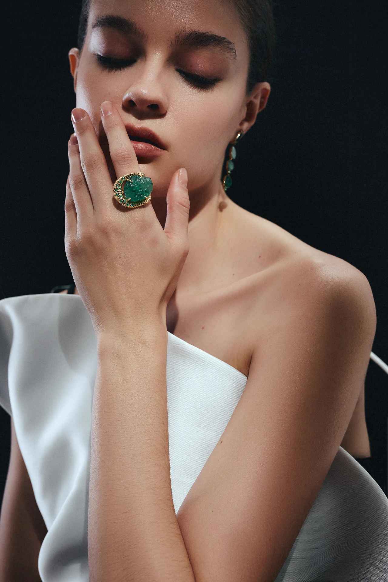 Anel ORIGEM em ouro 18k com esmeralda Belmont bruta, usado em editorial fundo preto
